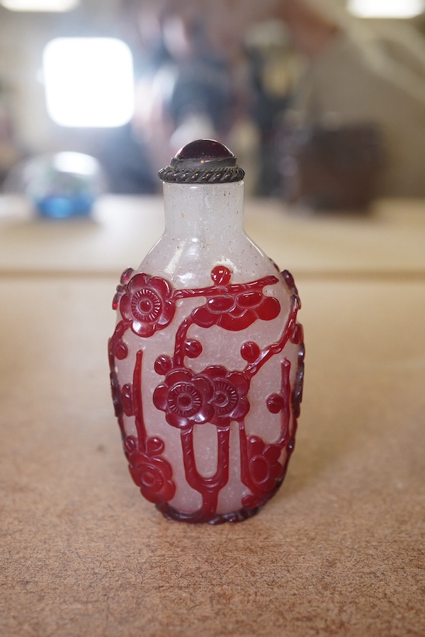 A Chinese cameo carved red overlaid on white snowflake ground snuff bottle and stopper, 19th century, 8cm high. Condition - small splinter chip to base, otherwise good